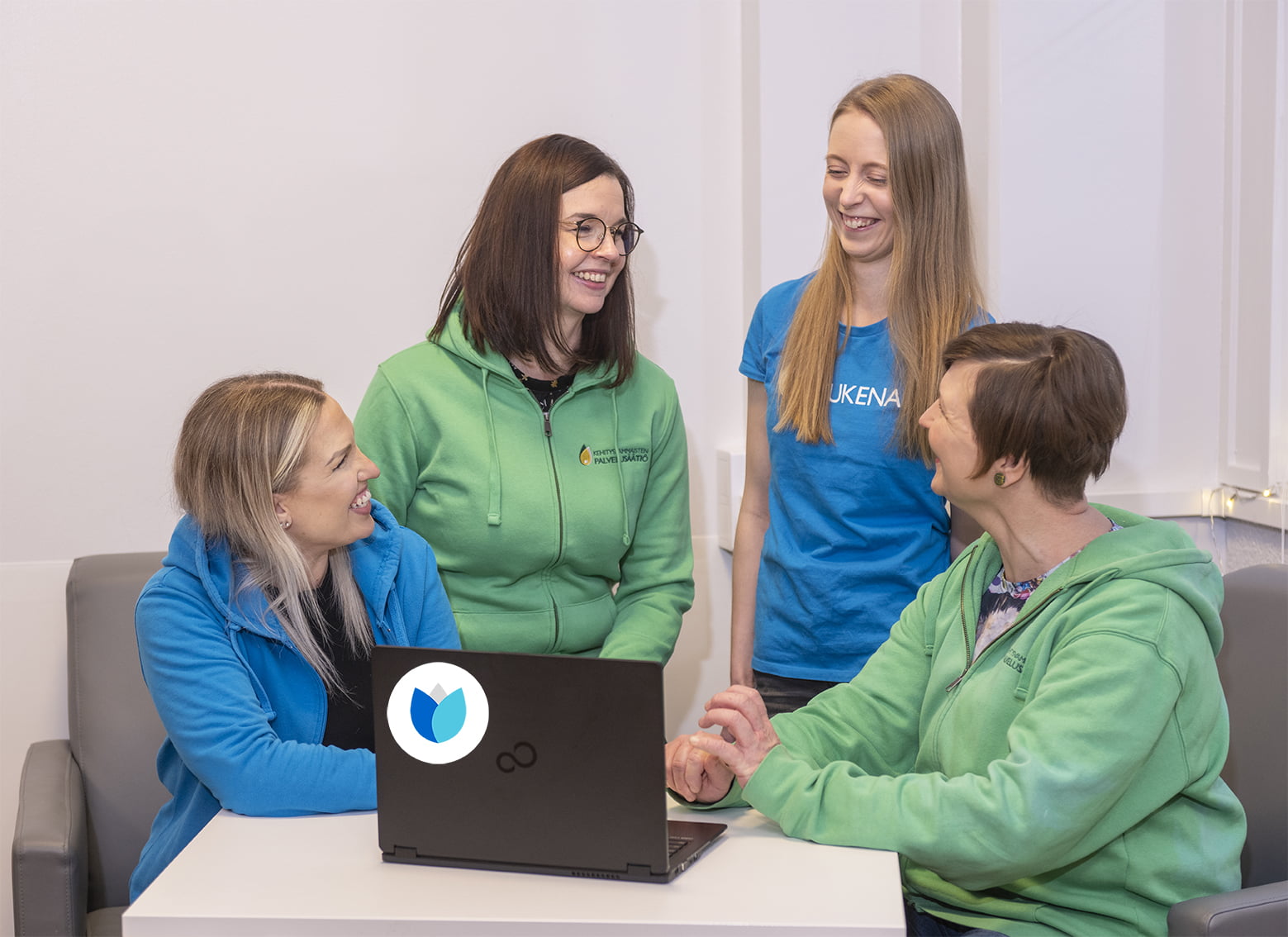 Työntekijöitä tietokoneen äärellä keskustelemassa